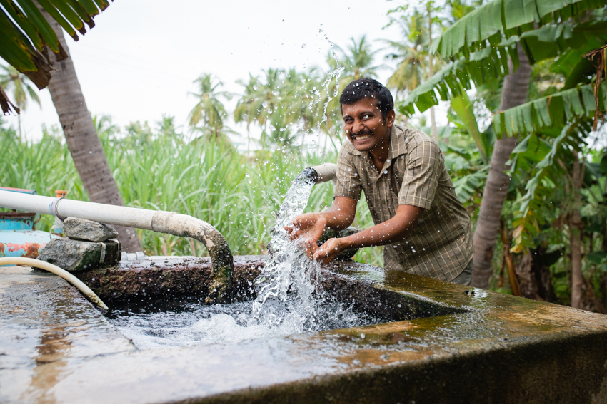 Happy Farmer Washing Hands in Pump Water