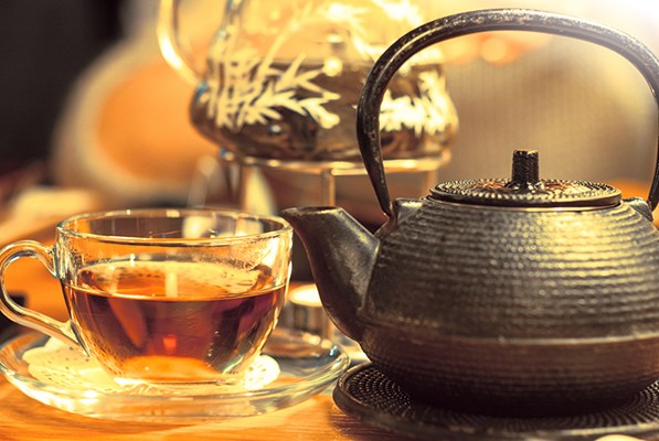 A cup of tea beside a kettle