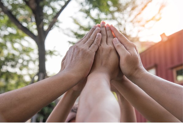 Raised arms joining together at the hands