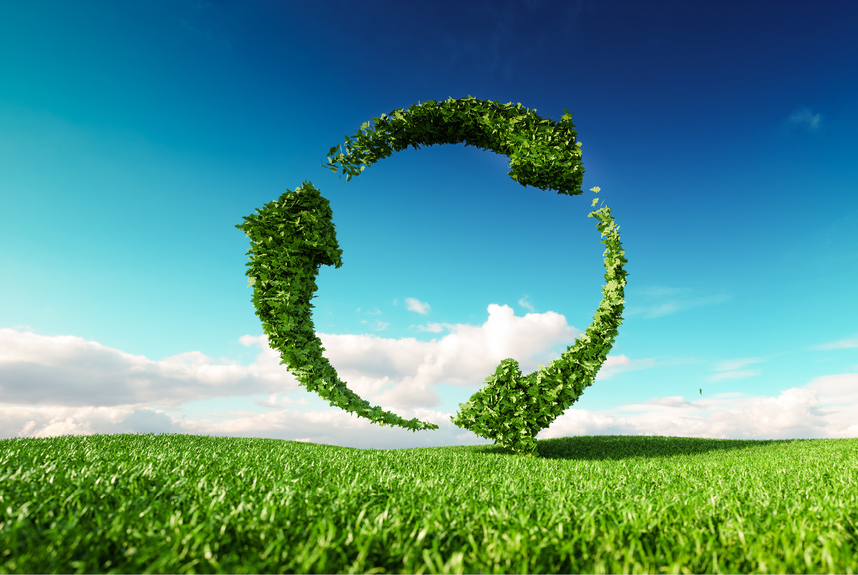 A green pictograph of the recycle symbol over a field