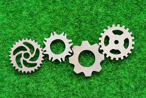 Three gears on a green field background