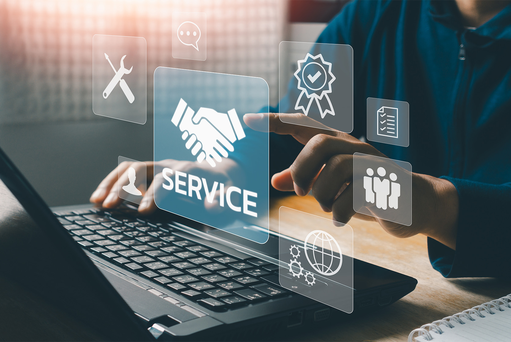 Technical support operator with virtual screen icons working on laptop computer